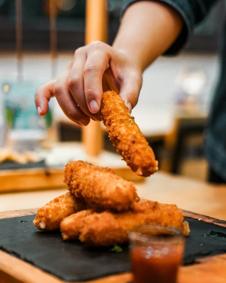 Krokante gefrituurde snacks op een leisteen met een bakje saus